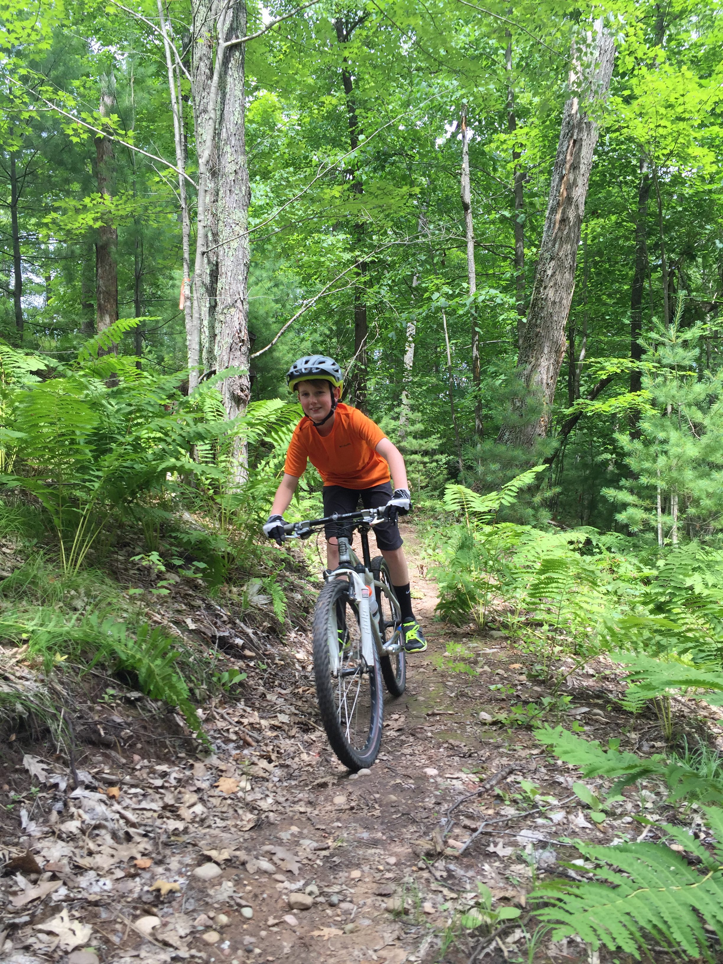 Boy biking Northwoods Zip Line Trail